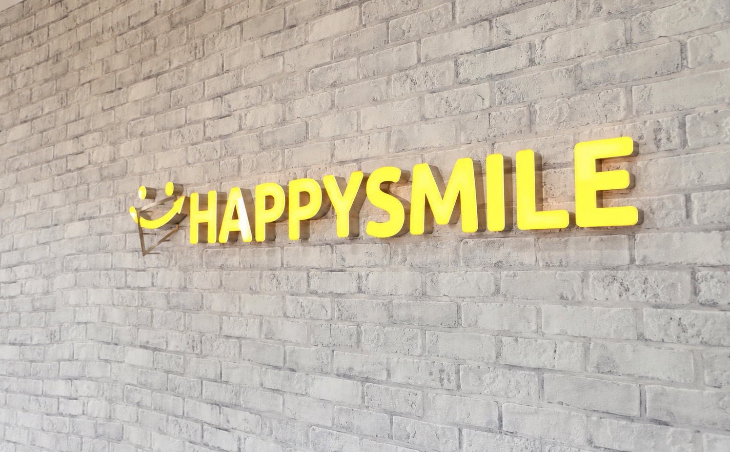 オフィスに掲げられたHAPPYSMILEのロゴサイン